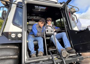 student sits in A cab as National Grid employee explains the equipment 