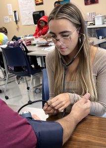 student checcks blood pressure