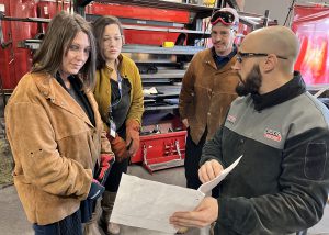 Counselors talking with welding teacher Don Mattoon