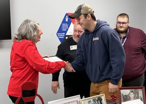 Senior smiles while shaking hands with scholarship presenter