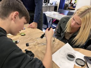 Students dust for fingerprints.