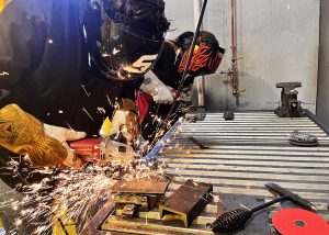 two students creating sparks while grinding metal