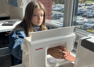 Student sews using a machine