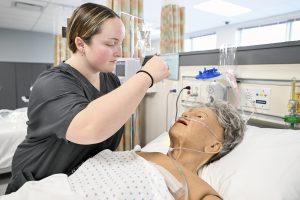 A student examines a mannequin 