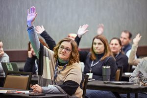 Event attendee raising hand during a session