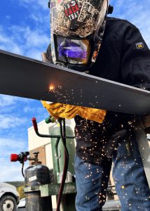 A student welding outside