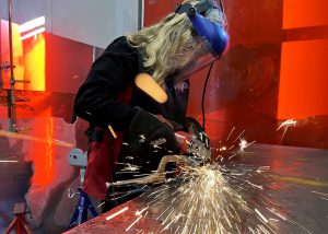 A student welds, creating sparks