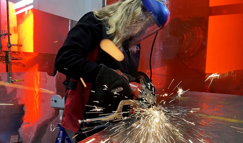 Sparks fly as a welding student works on a piece of metal.