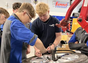 Students work on a tire