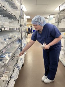 Sterile student in PPE putting instruments away at Albany Med