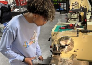 A student uses a lathe in a machine shop.