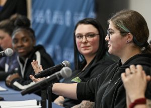 Students and adults speak on a panel 